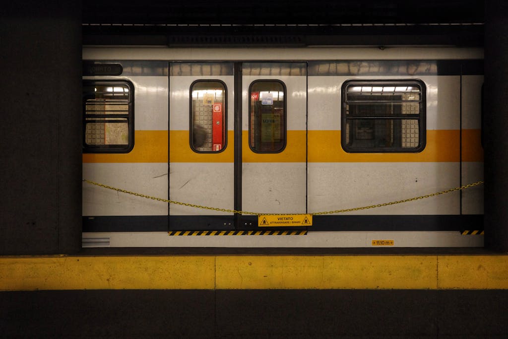 A Milano metro train parked at an empty underground station platform. mrt lrt