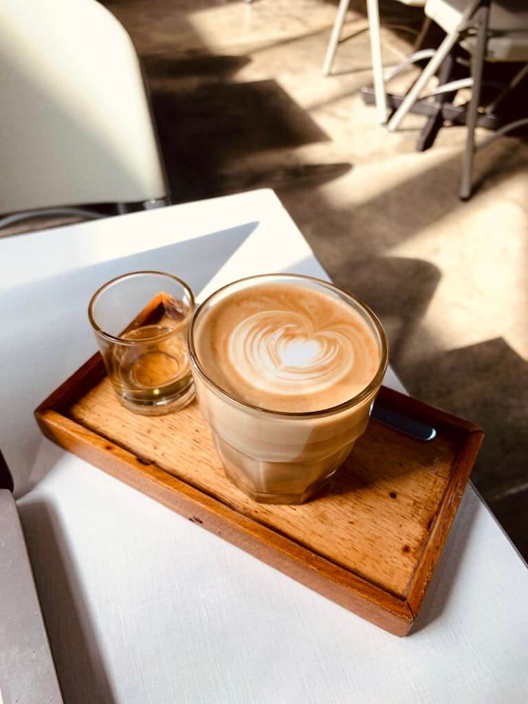 A perfectly crafted latte served on a wooden tray, capturing the essence of cafe culture. We love coffee @ Siargao