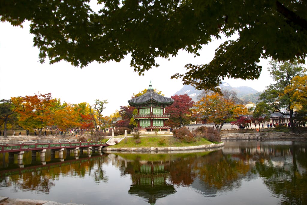 Beautiful reflection of Hyangwonjeong Pavilion surrounded by autumn colors in Gyeongbokgung Palace.
