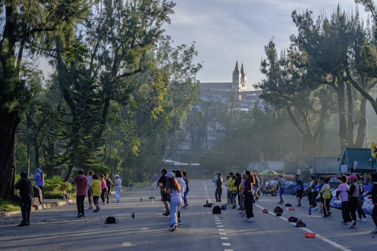 Group of people engaging in outdoor exercise on Baguio's Session Road in the Philippines.