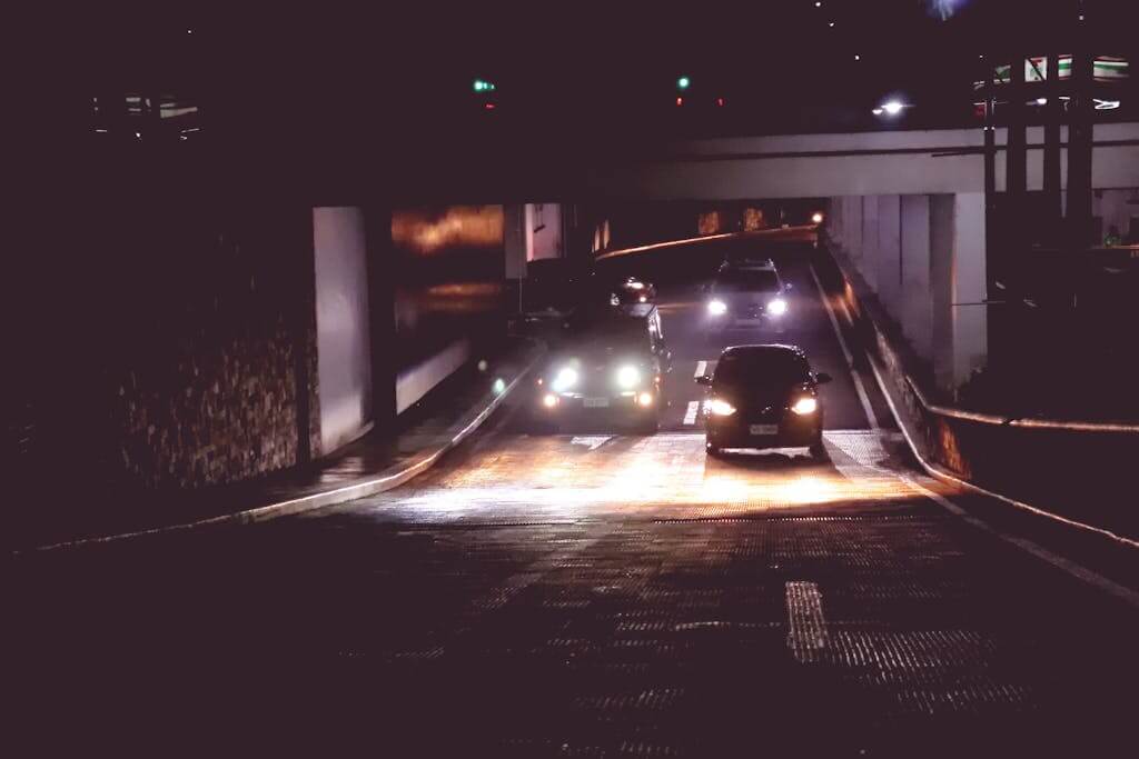 Illuminated cars driving through a tunnel in Makati, Philippines at midnight safety commute.