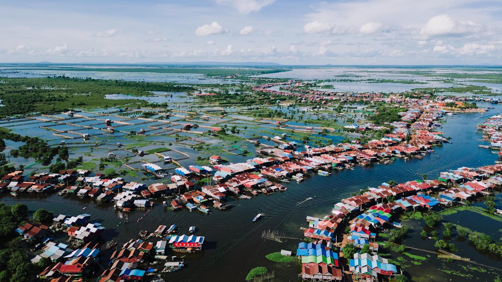 A stunning aerial view of the vibrant floating village in Kampong Khleang, surrounded by water and lush landscape. Cambodia trip