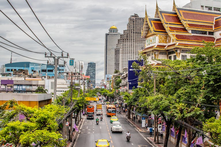 Bustling Bangkok street with traffic and iconic architecture. Urban life in Thailand's capital. Bangkok Thailand Tour