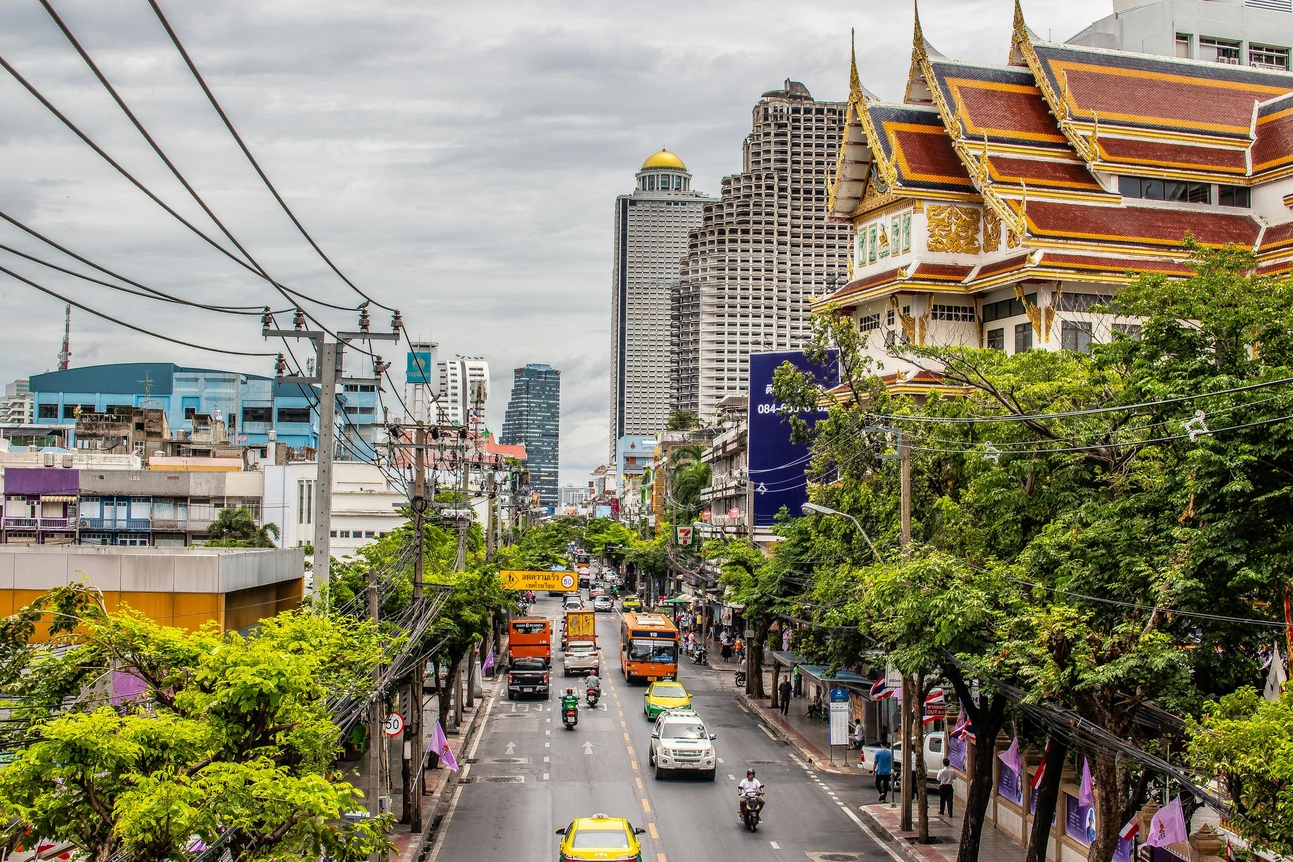 Bustling Bangkok street with traffic and iconic architecture. Urban life in Thailand's capital. Bangkok Thailand Tour