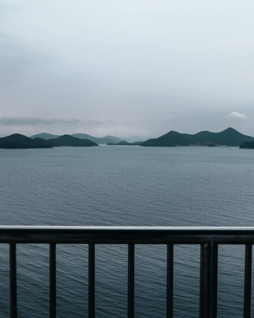 A serene view of Tongyeong's islands from a bridge. Calm sea under a cloudy sky. Tongyeong South Korea tour