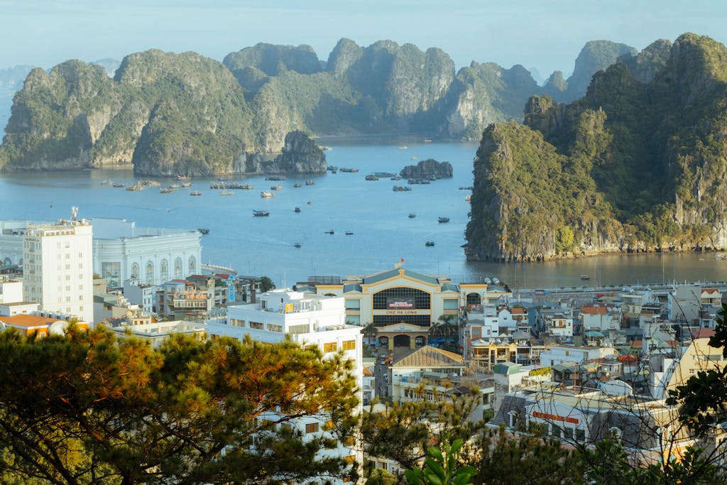 A stunning aerial view of Ha Long Bay, showcasing limestone karsts and urban landscape. Hanoi Ha Long Bay Vietnam tour