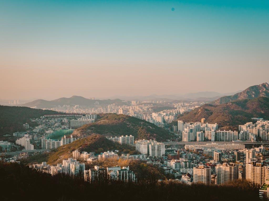 A stunning aerial view of Seoul's skyline with mountains and buildings under a clear sky. Seoul South Korea tour
