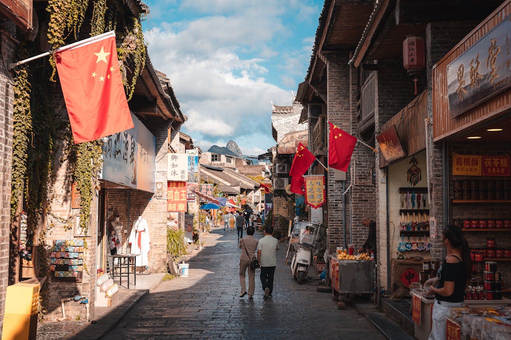 A vibrant street market scene in Xingping, China, showcasing traditional architecture and local shops.