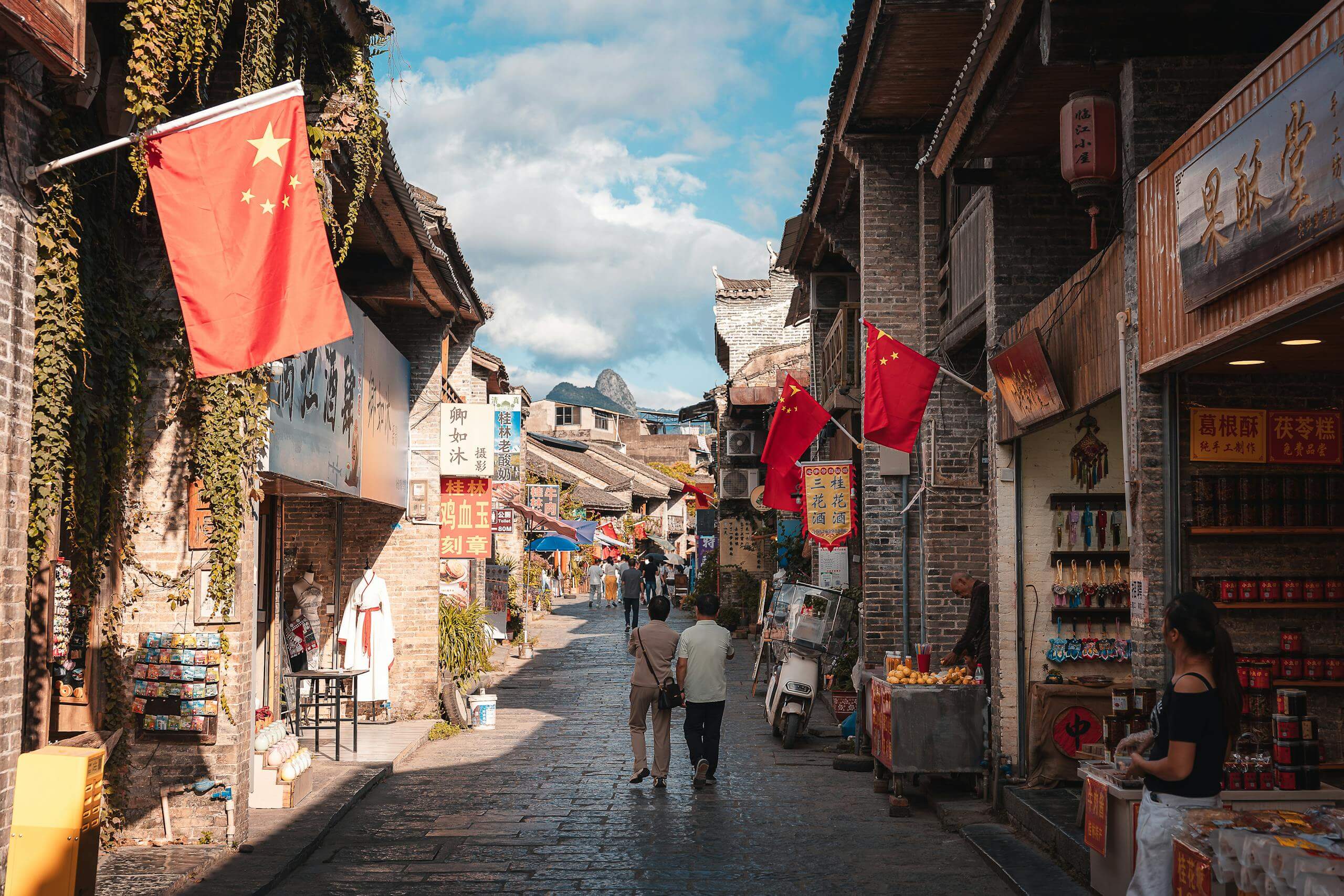 A vibrant street market scene in Xingping, China, showcasing traditional architecture and local shops.