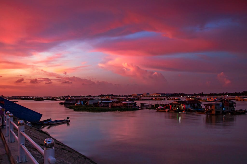 Capture the serene beauty of a sunset over the river in Long Xuyên, Vietnam.
