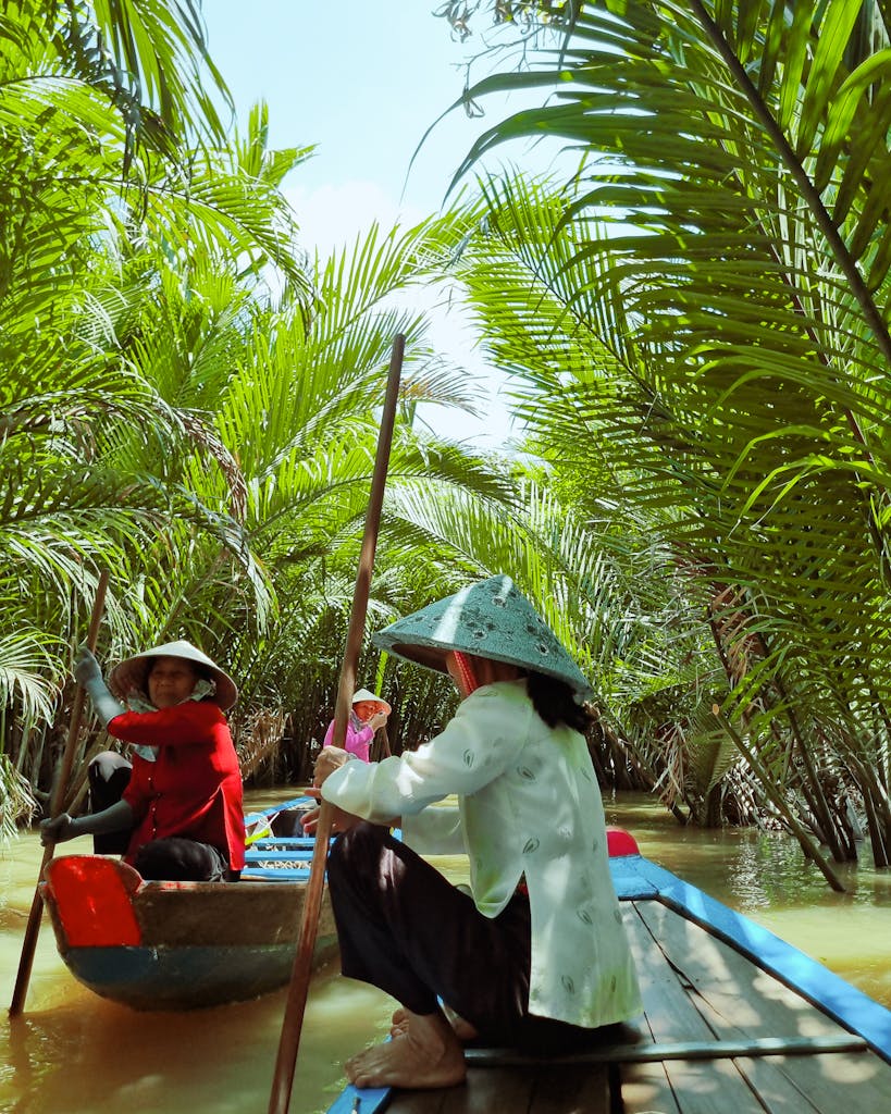 Experience a serene boat journey through lush palm trees in Vietnam's Mekong Delta.