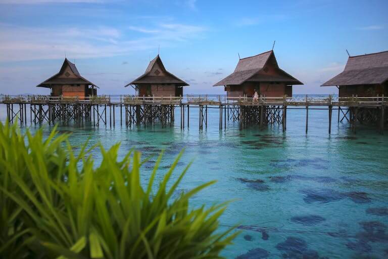 Scenic view of traditional wooden bungalows over turquoise waters in Malaysia.