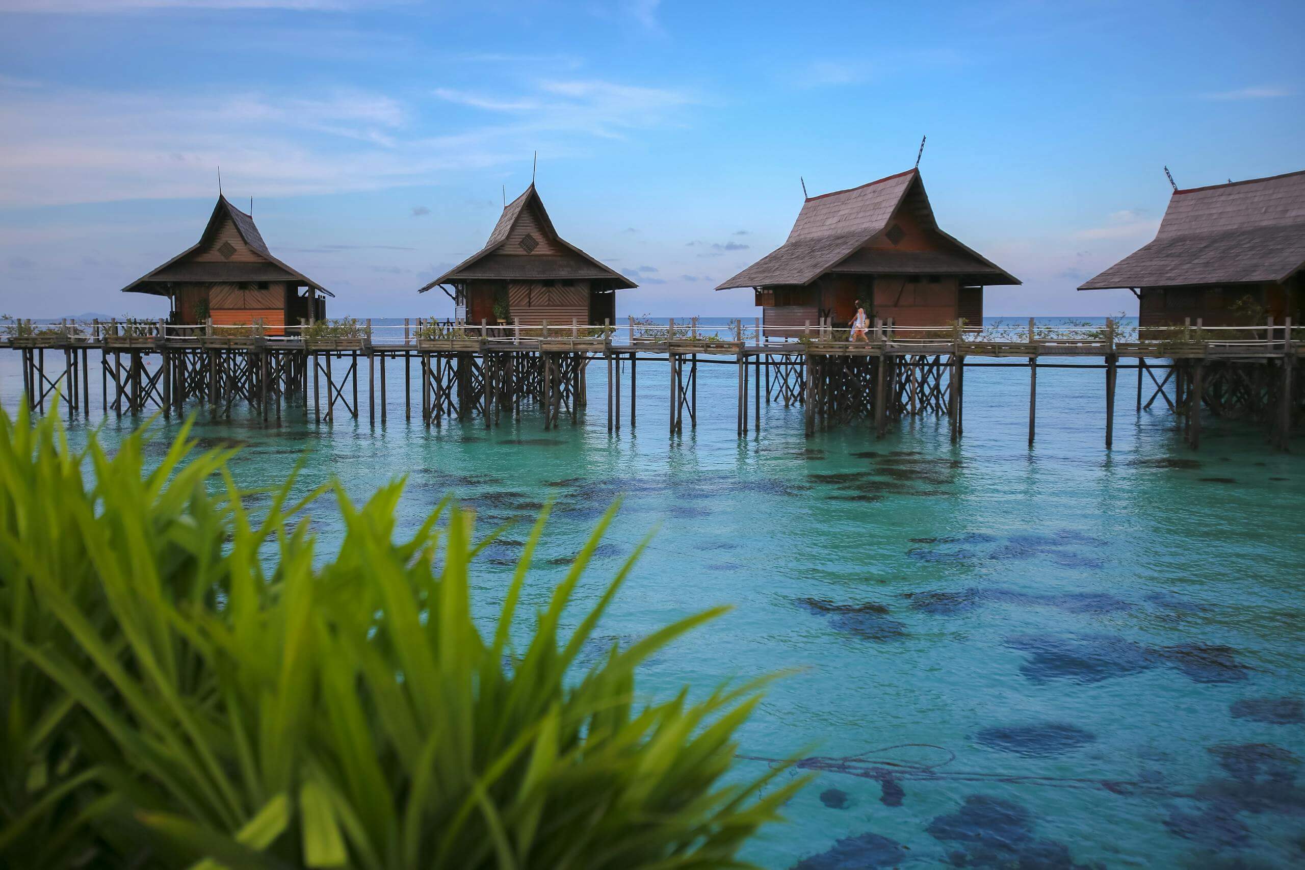 Scenic view of traditional wooden bungalows over turquoise waters in Malaysia.