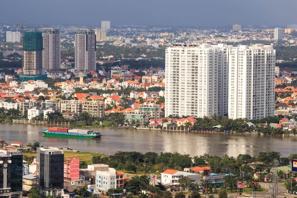 Stunning aerial view of Ho Chi Minh City skyline with Saigon River during sunset, showcasing urban architecture. Ho Chi Minh Vietnam tour