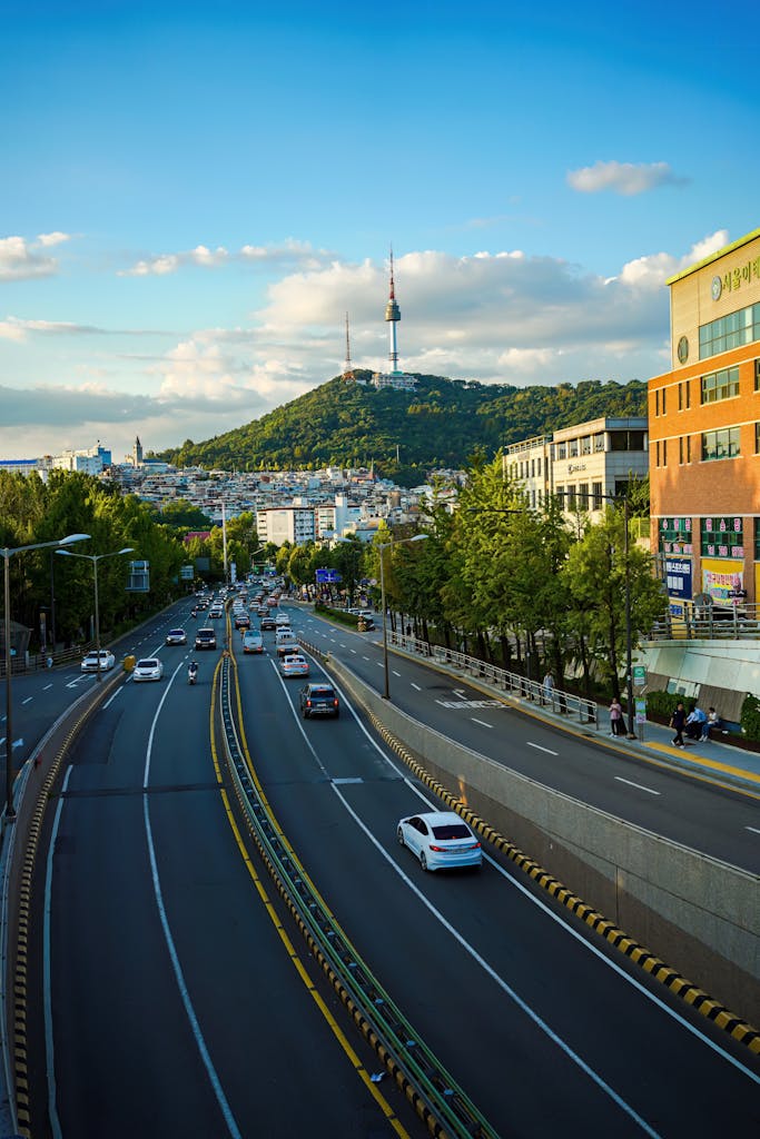 Vibrant view of Seoul city street leading to Namsan Tower, capturing urban life and scenic beauty.